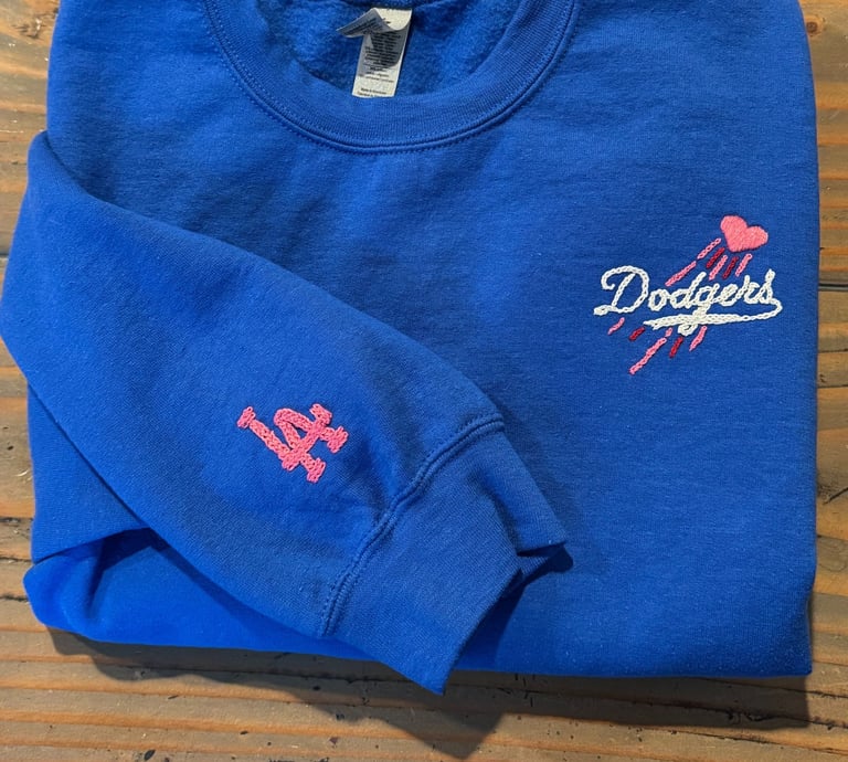 a blue sweatshirt with the dodgers logo on it