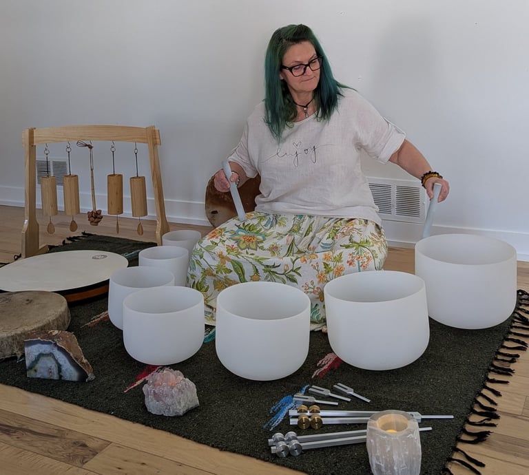 A woman playing on the sound bowls