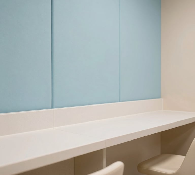 Architectural detail shot of eco-friendly materials and hygienic surfaces in a premium corporate lactation room in Hispanic / Corporate Latin America & Spain. Features soft pastel light blue sound-absorbing wall panels, smooth non-porous countertops, and subtle warm soft beige finishes. Clean professional interior photography.
