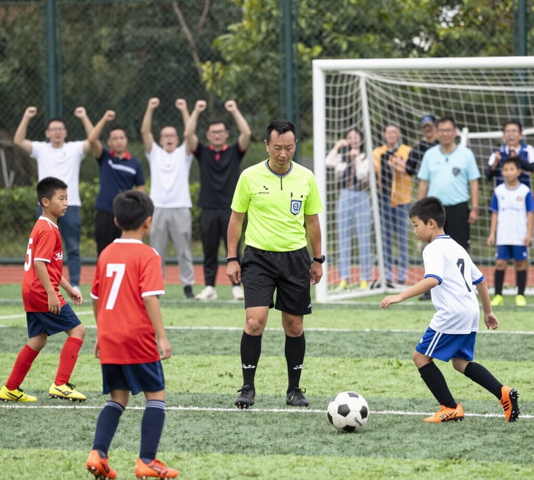 Children in colorful soccer uniforms joyfully playing a match on a sunny Saturday.