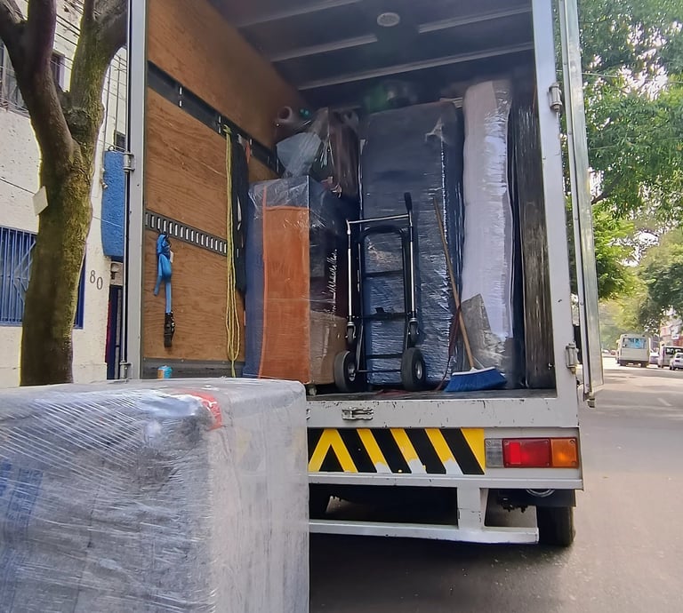 Equipo de Jhony Moving realizando mudanza profesional en CDMX con camión equipado y muebles