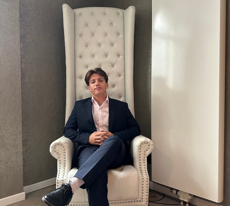 a man in a suit and tie sitting in a chair