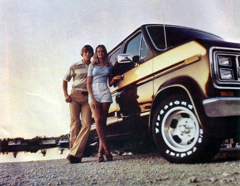 a couple of people standing next to a van