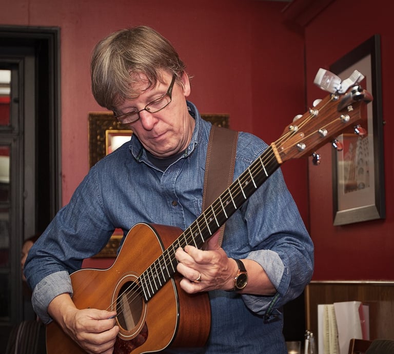 Man playing a guitar in a room