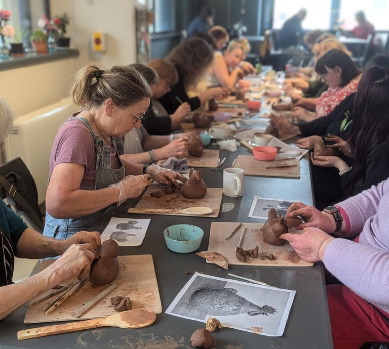 Commuinty Project - Group of people at into Bodmin creating clay pottery hens 