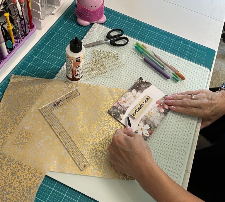 Linda is sitting at her craft desk making a Congratulations card.