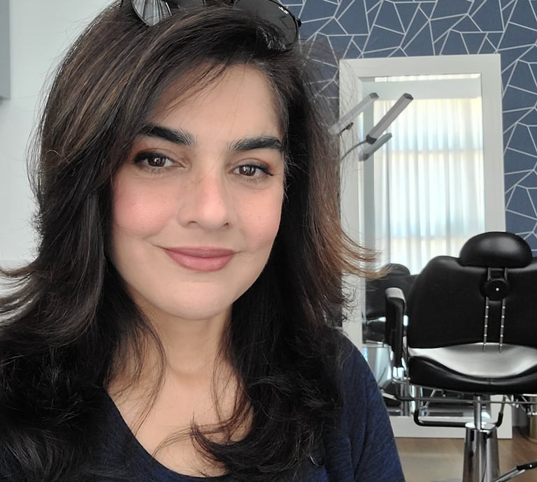 Shazia Ittiq, licensed permanent makeup artist in Oklahoma City, smiling at her desk