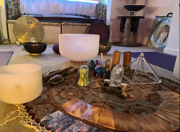 Sacred healing tools including crystals and sound instruments used alongside Reiki healing