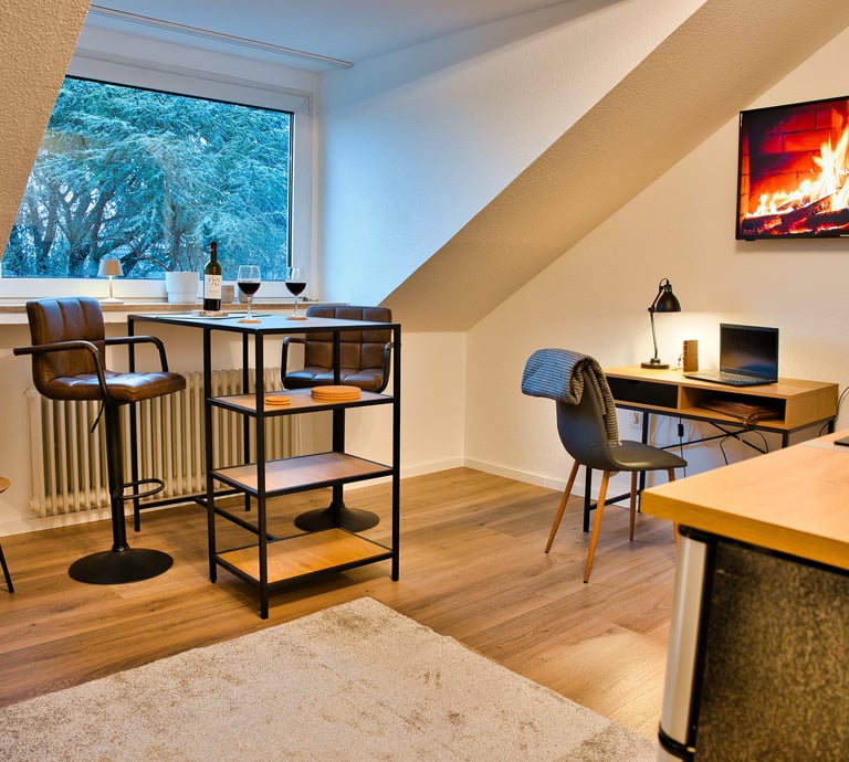 Business Apartment mit Schreibtisch, Hochtisch und Küche.