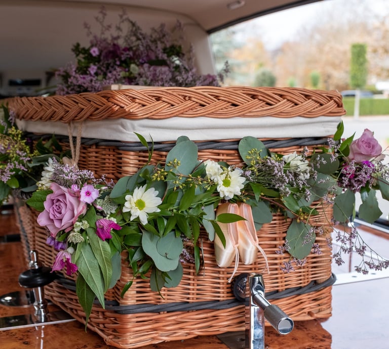 Wicker funeral casket decorated with fresh flowers
