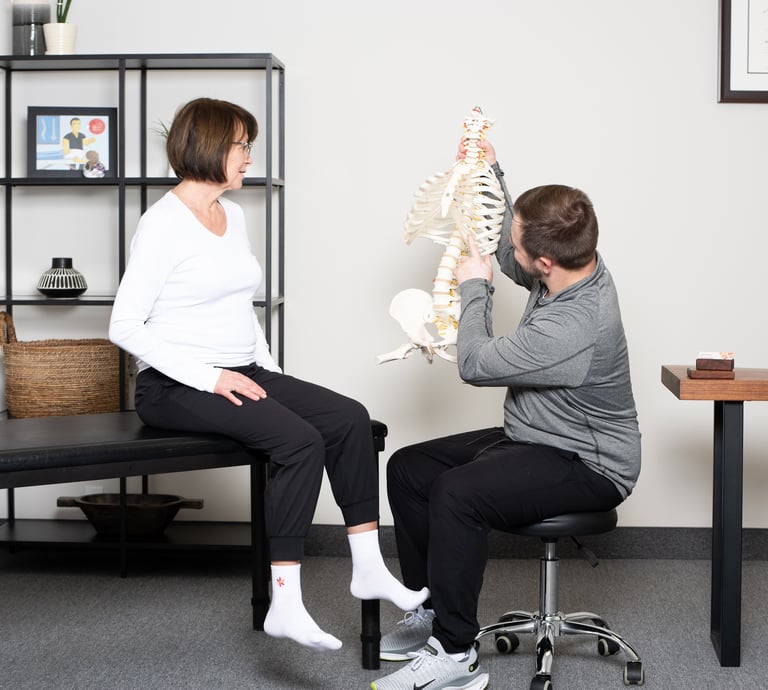 Osteopathic practitioner educating the patient on the spine