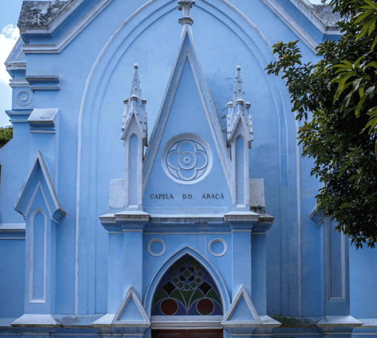 A imagem mostra a entrada da capela tradicional do cemitério araçá com fachada azul claro