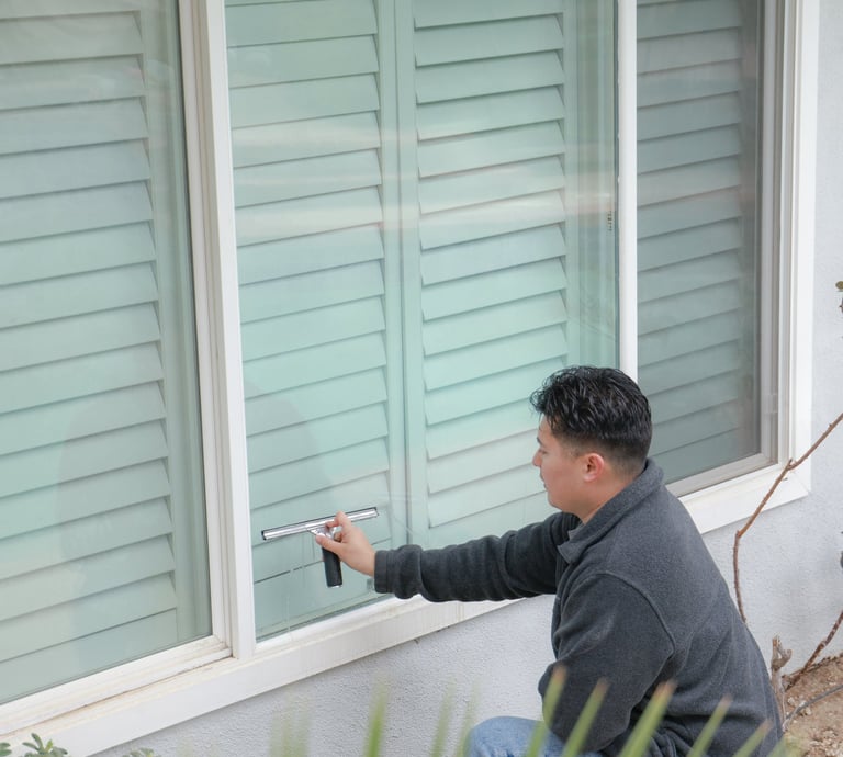 man with squeegee on window 