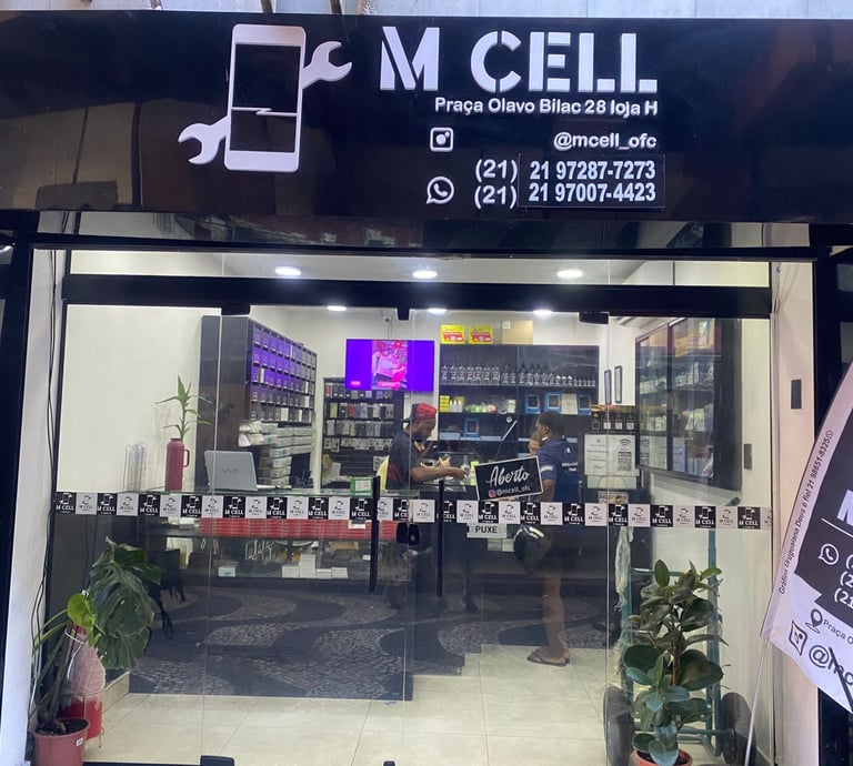 Storefront of M Cell, a mobile phone repair shop in Brazil featuring smartphone accessories and service technicians.
