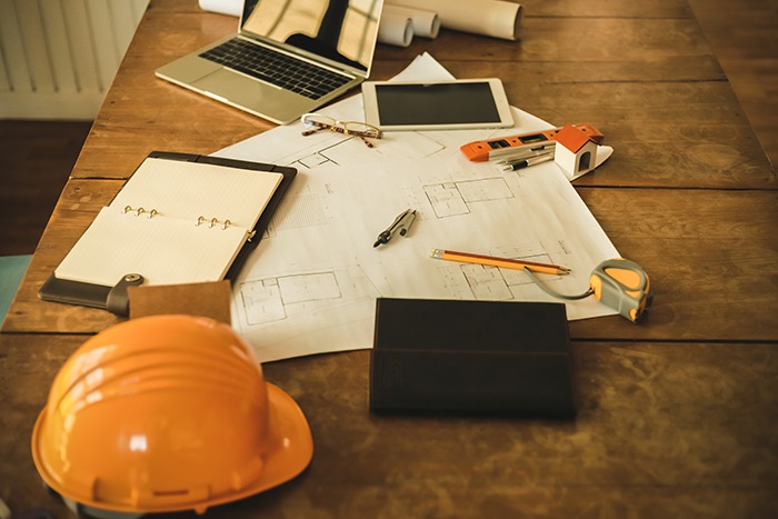 Laptop, capacete e ítens importantes para profissional de construção