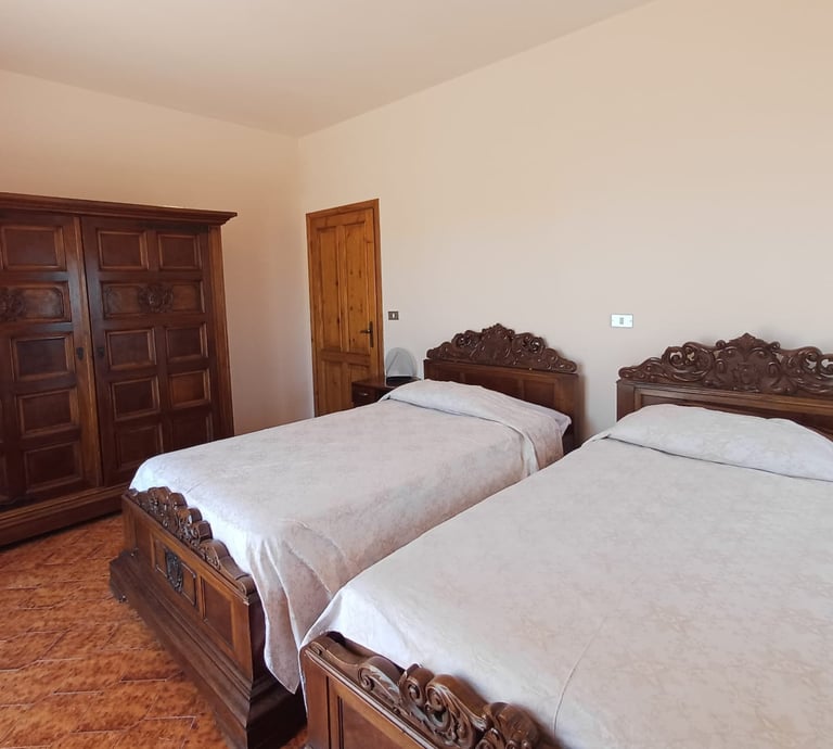 Camera doppia B&B Saludecio con due letti king size e arredi classici.