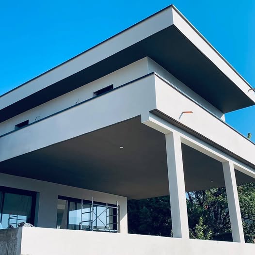 a white house with a large white roof and a large white building