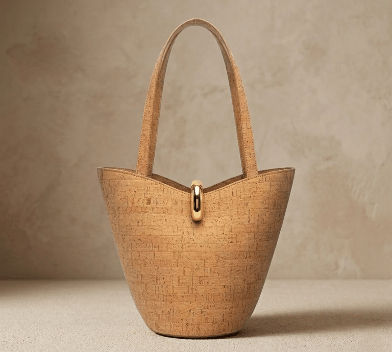 Handmade cork bucket bag with gold hardware and top handle, sustainable vegan fashion accessory.