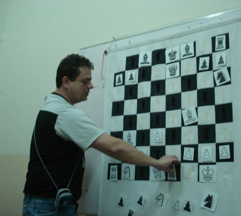 Reinaldo Mano durante uma aula de xadrez, movendo as peças em um quadro tabuleiro