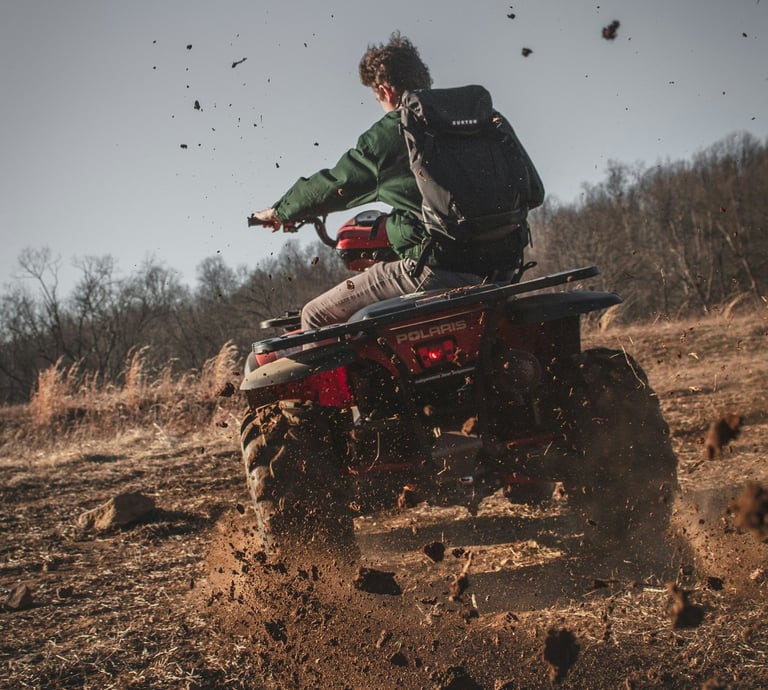 a man riding a quad - atv atv in the mud