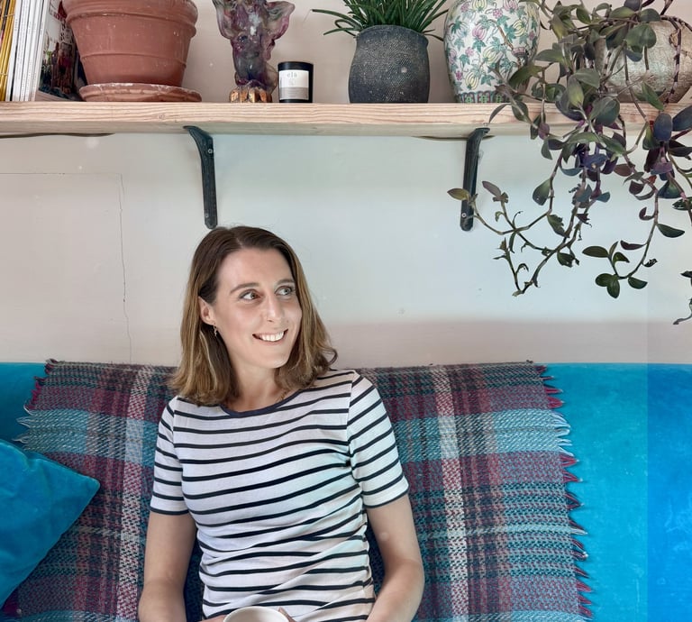 a woman sitting on a couch with a cup of coffee