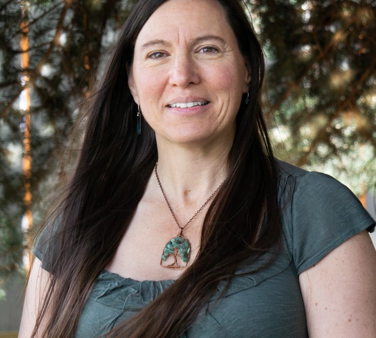 a woman with long hair and a necklace with a green leaf
