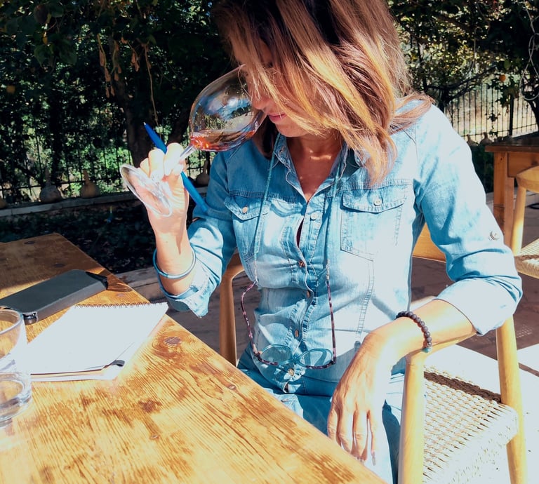 a french sommeliere sitting at a table with a glass of wine