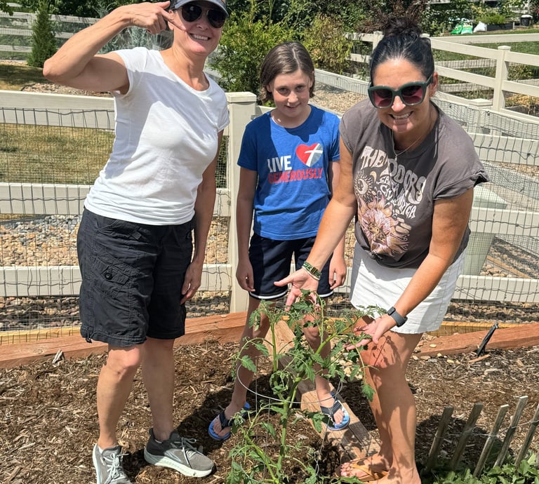 Prepped & Planted coach with clients excited about their growing tomato plant.