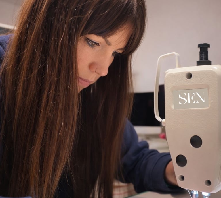 Foto de Sylvia, diseñadora de Sen Studio Atelier, cosiendo a maquina en su Taller en Alfajarin Zgz