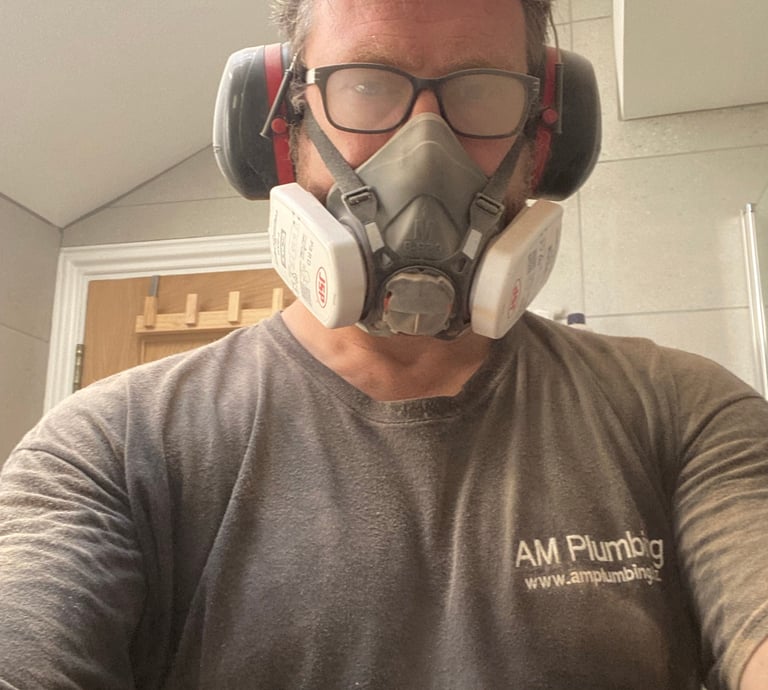 A very dusty owner of AM Plumbing after cutting through porcelain tiles to get to a leaking valve behind a tiled wall