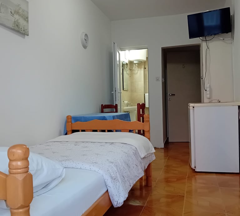 a bed with a television and a refrigerator