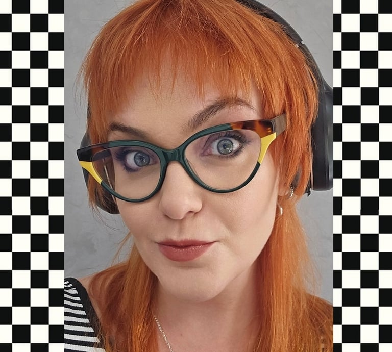 Gabriela Bechara Zillig. Mulher de pele branca, cabelos ruivos, olhos azuis e usa óculos verdes.