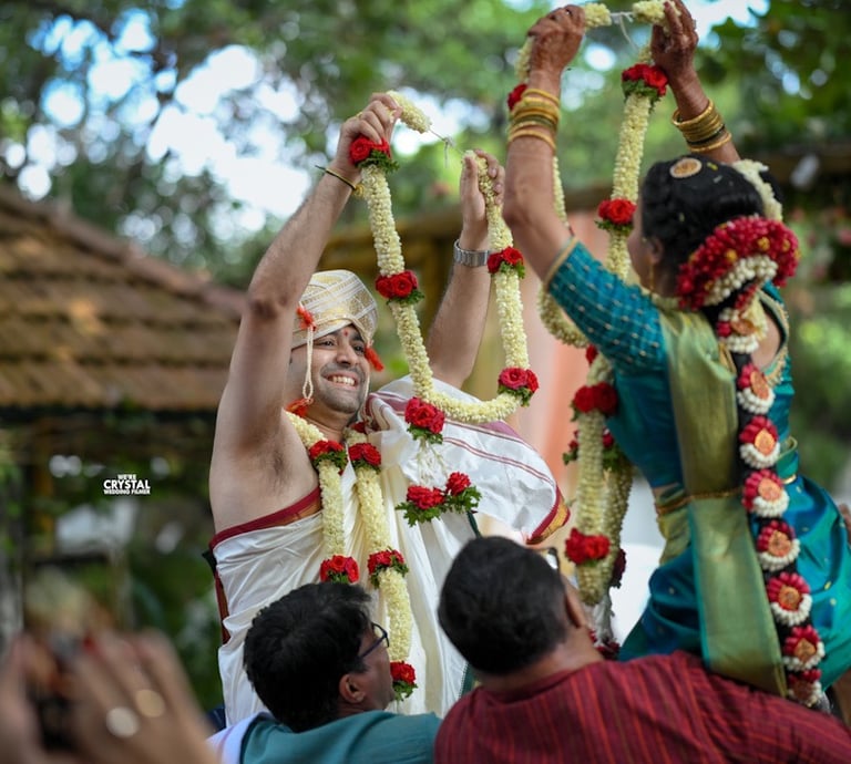 Bride and groom exchanging garlands on their destination wedding in Kerala