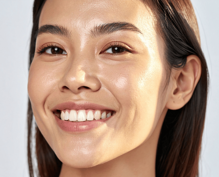close up of woman's face smiling with glowing skin
