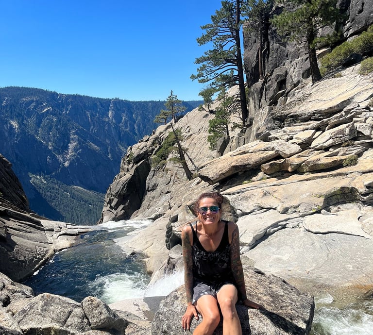 a woman sitting on a rock in a canyon
