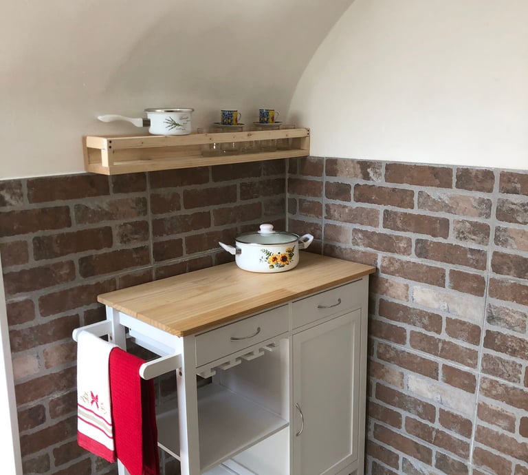 a kitchen with a small table and shelves