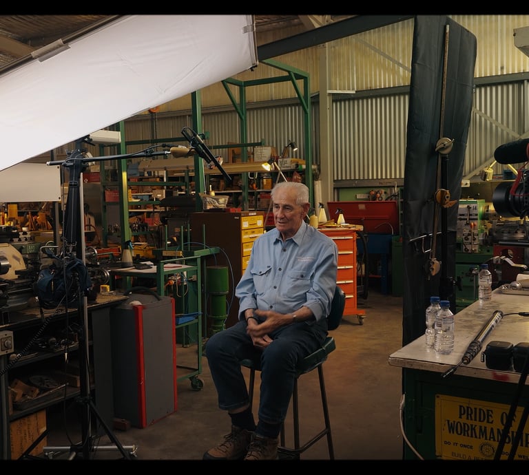 a man under a light modifier scrim while camera films