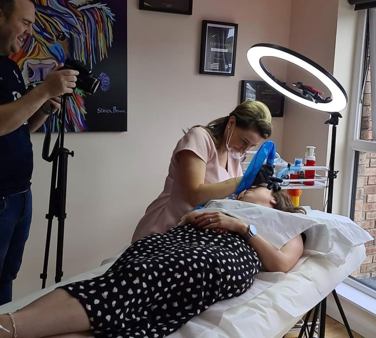 a woman is getting her hair done by a professional photographer