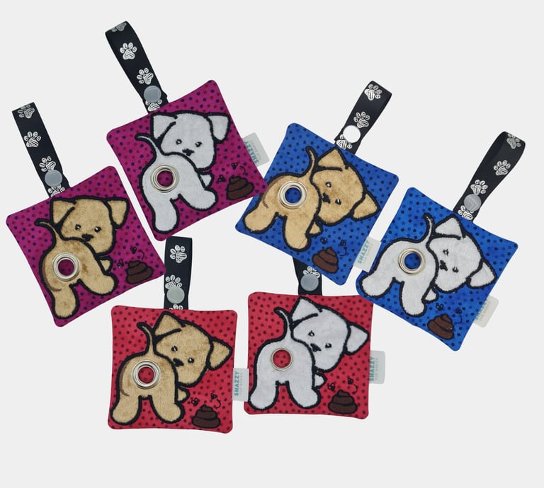 Colorful dog-themed keychains featuring plush designs, printed straps, and an embroidered poop bag holder