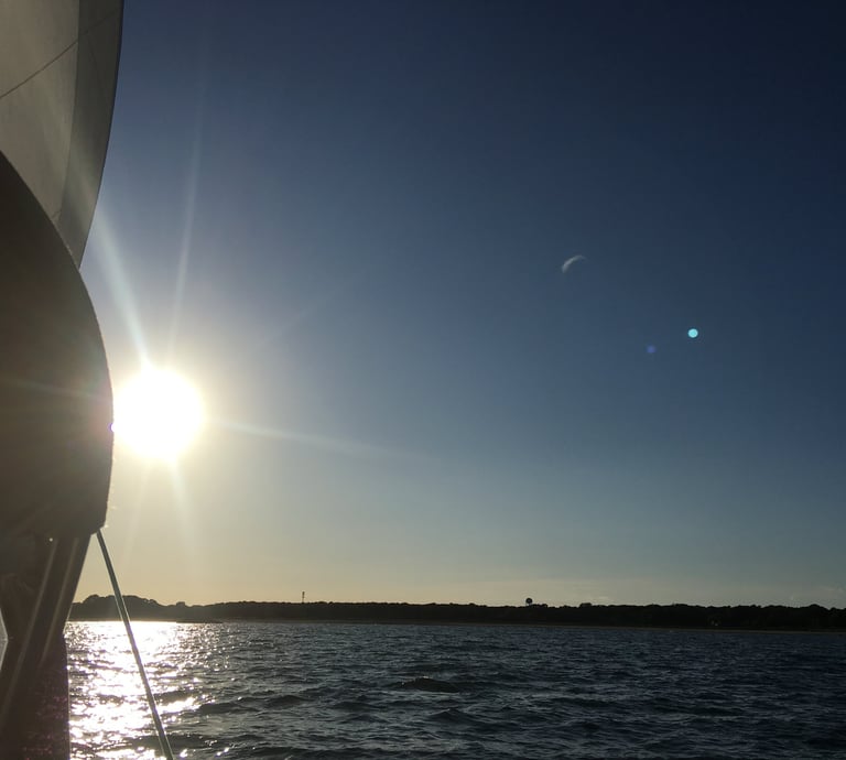 Sunset over water on a buzzards bay charter from a sailboat in Dartmouth Massachusetts