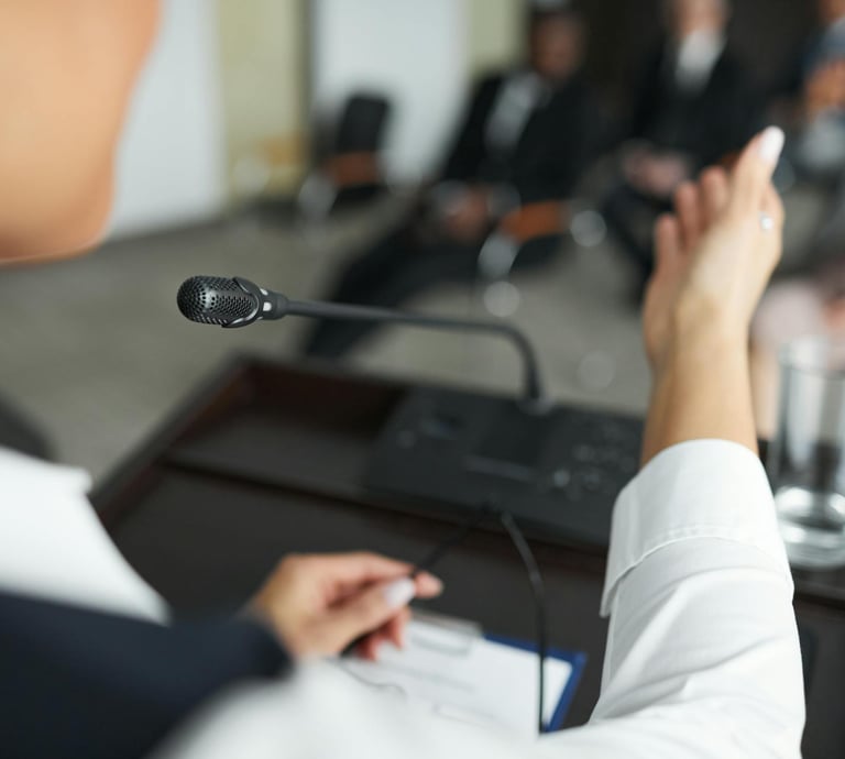 Close-up of a woman giving a speech from a lectern in a formal business atmosphere