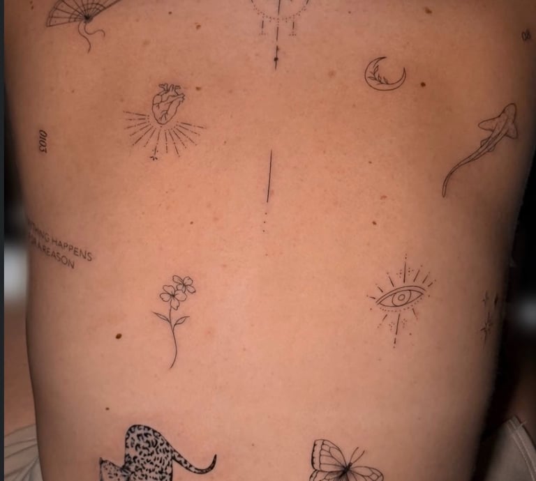 Tatuaje fine line en la espalda con flores y animales – Dasa Ink Barcelona