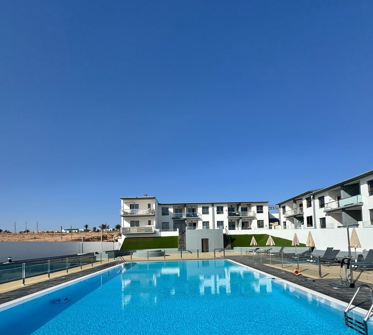 a pool with a lounge chair and lounge chairs