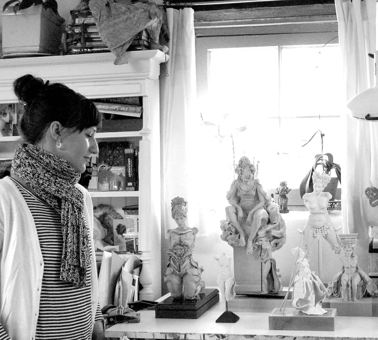 Artist Clea Carlsen in her studio with several finished sculptures.