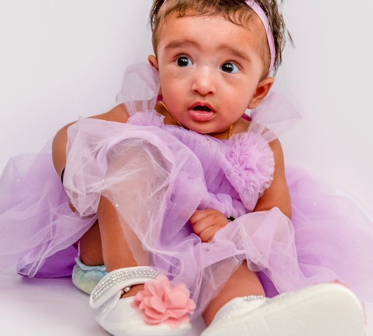 a baby girl in a purple dress and white shoes