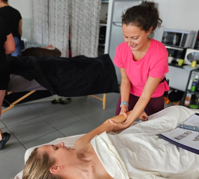 Massage de l'avant-bras avec masseuse et personne allongée sur le dos sous un drap
