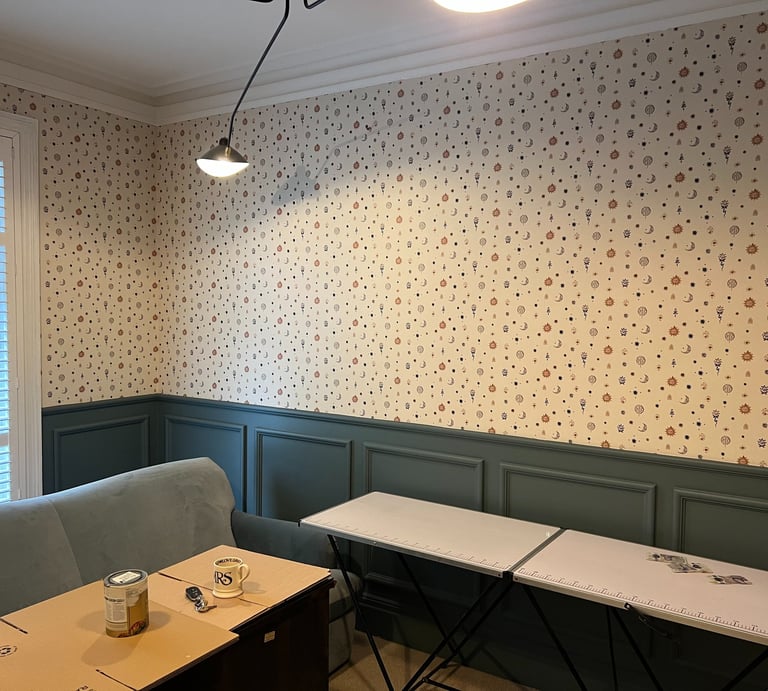 Room interior featuring celestial patterned wallpaper above dark teal board in East Sussex.