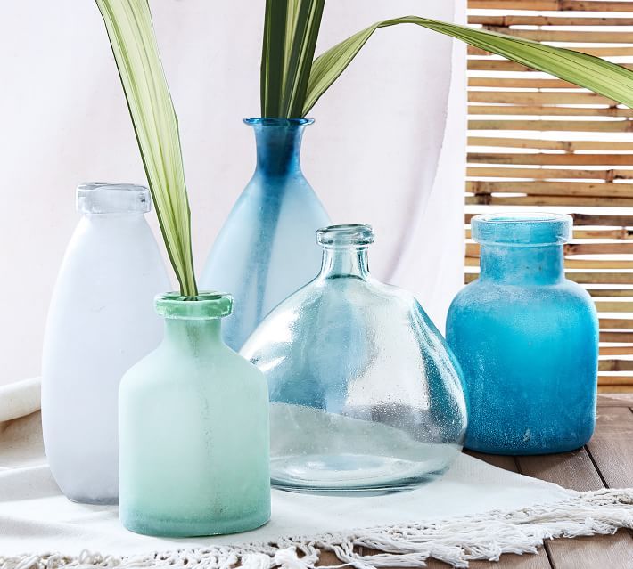 a table with galss vases of different coastal and sea colors