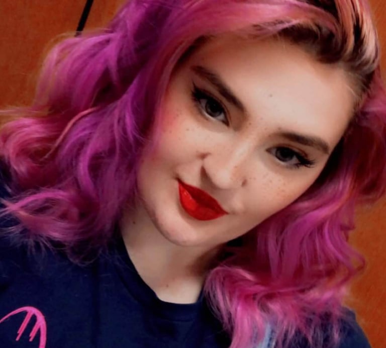 a woman with pink hair and a blue shirt