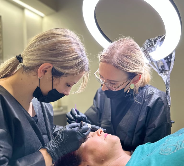 Darina y su estudiante haciendo cejas para una clienta